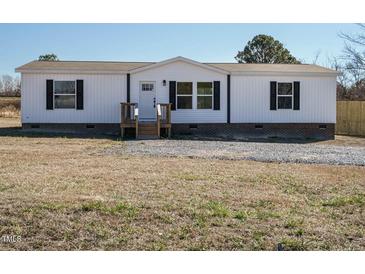 White single-wide manufactured home with black shutters and a wooden deck at 6567 Old Jefferson Davis Hwy, Cameron, NC 28326