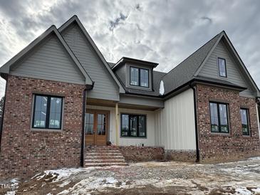 Two-story home with gray and brick exterior, and a covered front porch at 1401 Cottondale Ln, Wake Forest, NC 27587