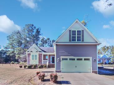 Two-story house with a large garage and landscaping at 1813 Ferrell Meadows Dr, Zebulon, NC 27597