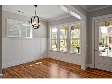 Bright dining room with hardwood floors, modern light fixture and large windows for natural light at 224 Wash Hollow Dr, Wendell, NC 27591