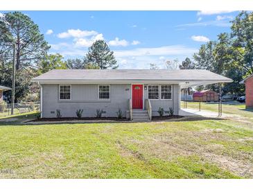Newly renovated single-story home with gray siding and a red front door at 609 E Cockrell St, Nashville, NC 27856