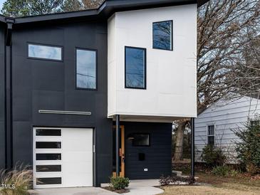 Modern two-story home with black and white exterior, attached garage, and landscaping at 707 Colleton Rd, Raleigh, NC 27610