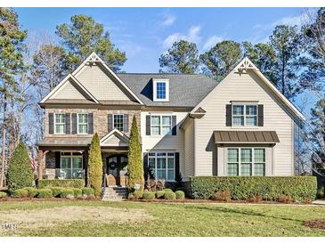 Two-story house with stone and shingle accents, landscaping, and a welcoming front porch at 7112 Hasentree Way, Wake Forest, NC 27587