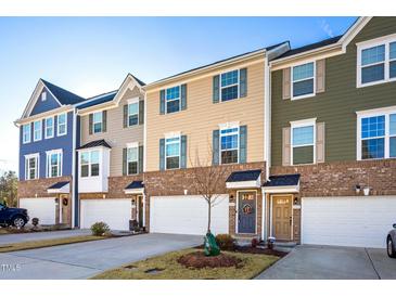 Charming townhomes with colorful facades, brick accents, and attached garages create curb appeal at 104 Ridgeline Ct, Durham, NC 27703