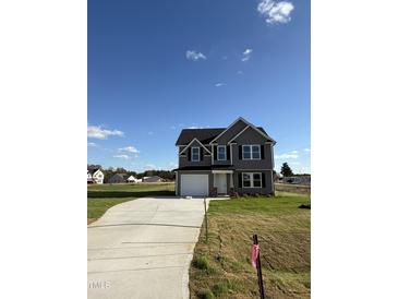 Two-story house with gray siding, a driveway, and a landscaped yard at 16 Shiloh Dr, Lillington, NC 27546