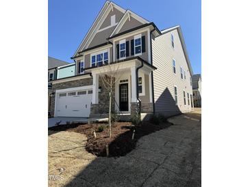 Beautiful two-story home featuring stone accents, a two-car garage, and a welcoming front porch at 2405 Englemann Dr # 121, Apex, NC 27502