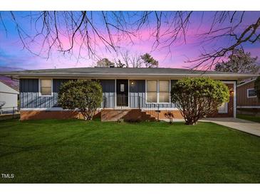 Ranch style home with gray siding, brick accents, and a well-manicured lawn at 2913 Sprucewood Dr, Durham, NC 27707