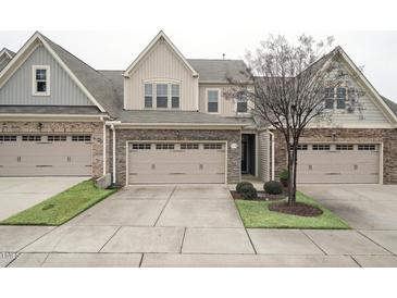 Two-story townhome with stone and siding exterior, two-car garage, and landscaping at 524 Brunello Dr, Wake Forest, NC 27587