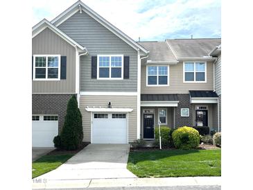 Charming townhome with a well-manicured lawn and attached garage, showcasing appealing curb appeal at 7205 Ladbrooke St, Raleigh, NC 27617