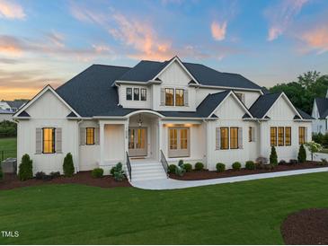 A beautiful two-story home with white siding, dark roof, manicured lawn, and inviting front entrance at 1608 Legacy Ridge Ln, Wake Forest, NC 27587
