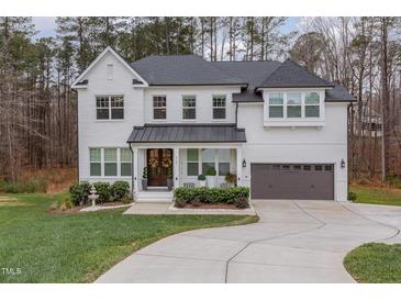 Two story white brick home with gray roof and a 3-car garage at 8101 Fergus Ct, Wake Forest, NC 27587