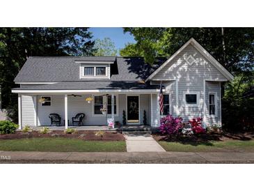 Charming single-Gathering home with a inviting front porch, beautiful landscaping and American flag at 223 N Main St, Wendell, NC 27591