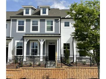 Charming two-story townhome with gray and white siding, dormer windows, and a black wrought iron fence at 494 Traditions Grande Blvd # 25, Wake Forest, NC 27587
