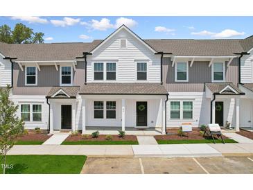 Three-unit townhome building with white and gray siding, landscaping, and parking at 124 Camel Crazies Pl # 43, Lillington, NC 27546