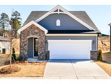 Charming home with stone accents, a two-car garage, and well-maintained landscaping at 213 Little Crk Dr, Lillington, NC 27546