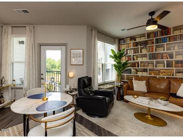 Inviting living room featuring a stylish bookcase wall and modern furnishings at 2313 Gathering Square Ct # 2313, Fuquay Varina, NC 27526