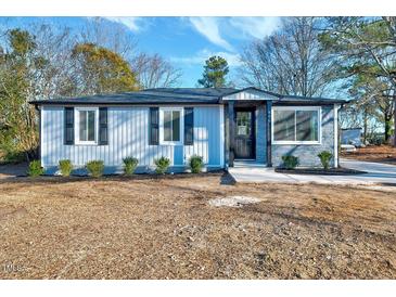 Newly renovated home with gray siding, stone accents, and landscaping at 406 Everette Ave, Clayton, NC 27520