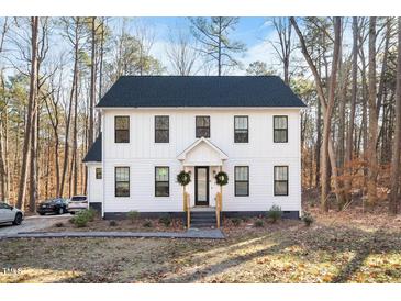 Two-story white farmhouse with black windows, and a welcoming front porch at 113 Laurston Ct, Durham, NC 27712