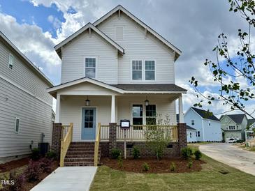 Charming two-story home with a inviting front porch and a light blue front door at 129 Mossy Falls Way, Wendell, NC 27591