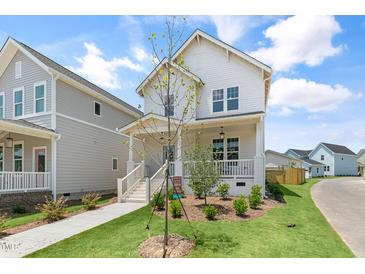 Charming two-story white home featuring a welcoming front porch and well-manicured lawn at 129 Mossy Falls Way, Wendell, NC 27591