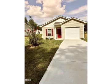 Tan house with red door, single car garage, and landscaped lawn at 159 Bywood Dr, Roxboro, NC 27573