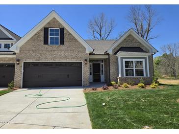 Charming single-Gathering home with a brick facade, well-manicured lawn, and an attached two-car garage at 2094 Harris Farm Ct, Burlington, NC 27215