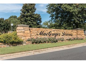 Stone community entrance sign for MacGregor Downs with beautiful landscaping and a clear blue sky above at 501 Queensferry Rd, Cary, NC 27511