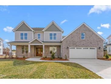 Beautiful two-story home with brick accents, a well-manicured lawn, and a two-car attached garage at 1246 Jamestowne Dr, Elon, NC 27244