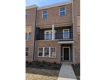 Modern brick townhome with covered entry and balcony, offering stylish urban living at 205 Broomgrove Way, Wake Forest, NC 27587