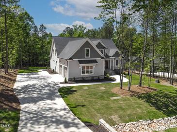 Stunning two-story home featuring a long driveway, mature trees, and a well-manicured lawn at 3923 Cedar Knolls Dr # 12, Youngsville, NC 27596