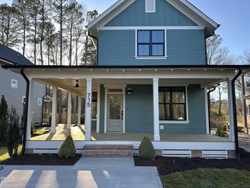 Charming two-story home showcasing a covered porch with white pillars and teal siding at 715 Heidelberg St, Durham, NC 27704
