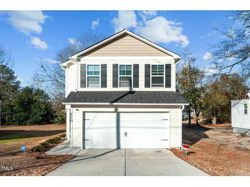 Two-story house with a white garage door and beige siding at 810 Brake St, Nashville, NC 27856