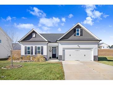 Two-story Craftsman home with gray and white exterior, two-car garage, and landscaping at 142 Jade St, Smithfield, NC 27577