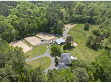 Expansive estate featuring stables, riding area, and a well-maintained home amidst lush greenery at 265 Verde Rd, Apex, NC 27523