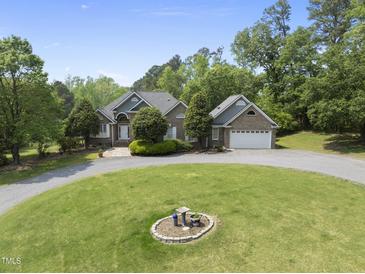 Charming brick home with well-manicured lawn and a circular driveway showcasing its curb appeal at 265 Verde Rd, Apex, NC 27523