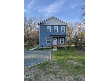Charming two-story home featuring light blue siding, a covered front porch, and a well-maintained lawn at 343 Foster St, Burlington, NC 27217