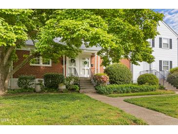 Charming brick townhouse with a welcoming front entrance and lush landscaping at 1621 Sutton Dr, Raleigh, NC 27605