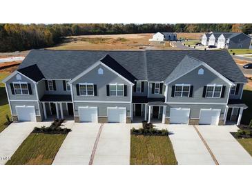 Three-unit townhome building with gray siding and two-car garages at 285 Moyer Dr # 119, Graham, NC 27253