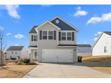 Two-story house with gray siding, a white garage door, and a well-maintained lawn at 326 Armistead Ct, Burlington, NC 27217
