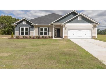 Two-story house with a beige exterior, gray roof, and white garage door at 572 Glenkirk Pl, Garner, NC 27529