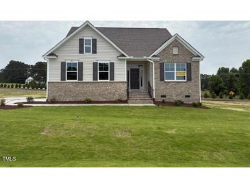 Charming home featuring brick and vinyl siding, inviting entryway, and a well-manicured lawn at 93 Ausban Ridge Ln # 033, Four Oaks, NC 27524