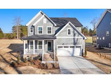 Charming two-story home featuring a well-manicured lawn, covered porch, and attached two-car garage at 102 Belmont Stakes Ln, Wendell, NC 27591