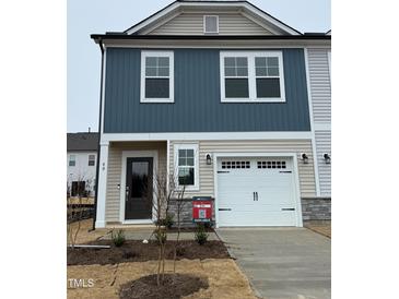 Two-story home with neutral siding, white garage door, and landscaping at 40 Shay St, Angier, NC 27501