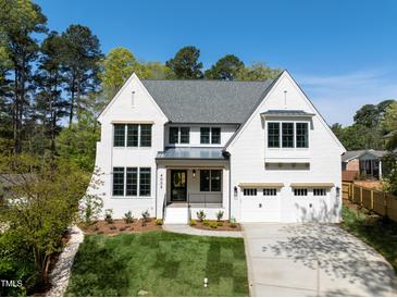 Stunning two-story home with a manicured lawn, attached garage, and classic white painted brick at 4005 Brevard Pl, Raleigh, NC 27609