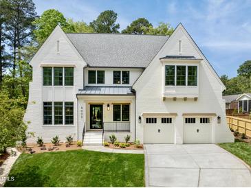 Striking white brick home with a manicured lawn and two-car garage at 4005 Brevard Pl, Raleigh, NC 27609