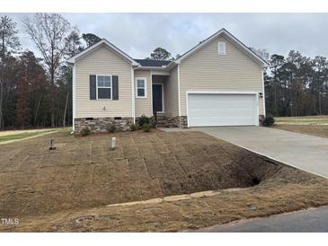 Beige house with a two-car garage and stone accents at 507 Barnes Landing Dr, Four Oaks, NC 27524