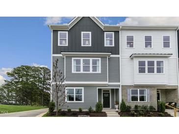 Two-story townhome with gray and white siding, and landscaping at 703 Lucky Clover Way, Fuquay Varina, NC 27526
