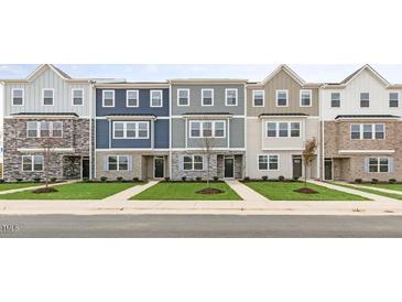 New townhome community featuring three-story townhouses with modern brick and siding at 705 Lucky Clover Way, Fuquay Varina, NC 27526