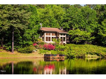 Luxury lakefront home nestled in lush woods with private dock at 10305 Old Creedmoor Rd, Raleigh, NC 27613