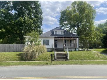 Charming single-story home with a classic front porch and a cozy, welcoming feel on a partially cloudy day at 614 Tucker St, Burlington, NC 27215